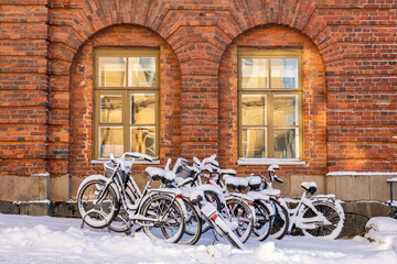 Fototapeta na wymiar Bicycles left in a parking spot with a thick layer of fresh snow.