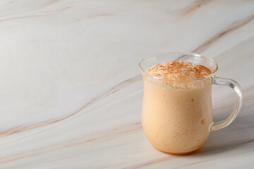 Delicious eggnog on white marble table. Space for text