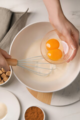 Woman mixing ingredients at white marble table, top view. Cooking delicious eggnog
