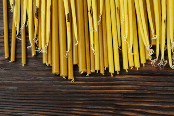 Many church candles on wooden table, flat lay. Space for text