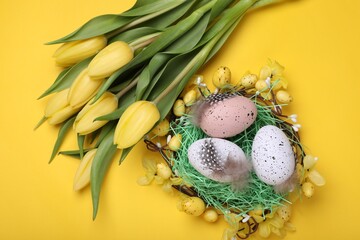 Flat lay composition with beautiful flowers and eggs on yellow background. Easter celebration