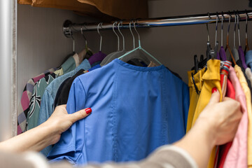 Fototapeta na wymiar woman taking blouse out of wardrobe at home.
