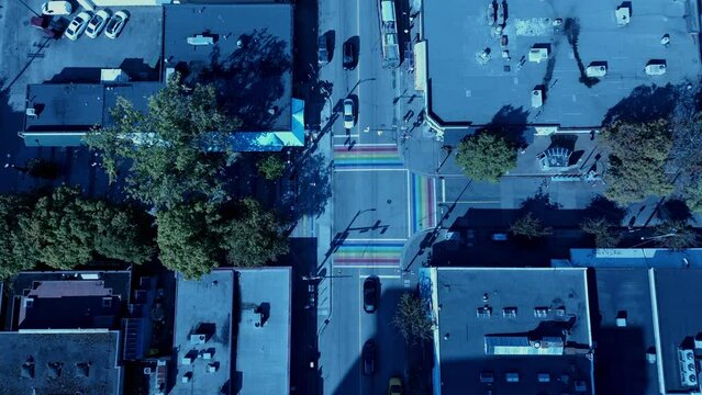 Davie Bute Jim Diva Plaza Top View 4k Drone light traffic sunny day rainbow sidewalk first painted street in Canada to represent LGBTQ community with steady zoom public transit trolley bus drives by