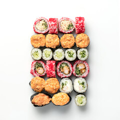 Large set of different types of sushi rolls. Rolls baked, rolls with caviar, rolls with avocado. Japanese food. Seafood dishes. View from above. Isolate on white background. Copy space. 