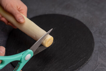 kitchen scissors cut leeks on a slate cutting board in the kitchen