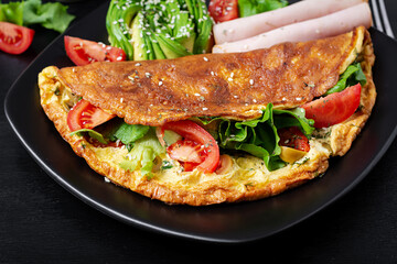 Keto breakfast. Omelette tomato, olives and avocado, ham. Ketogenic diet. Low carb high fat breakfast. Healthy food concept.