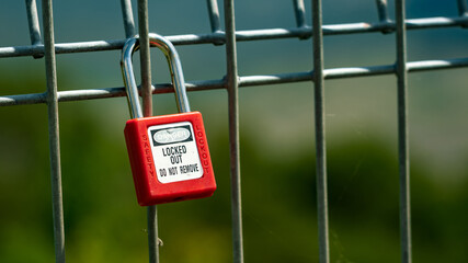 Red padlock attached to a fence as a sign of eternal love