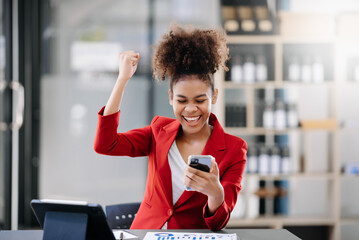 Asian business woman are delighted and happy with the work they do on their tablet, laptop and taking notes at the office..