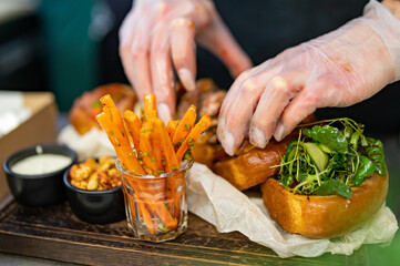 woman chef hands in gloves cooking sandwich on kitchen
