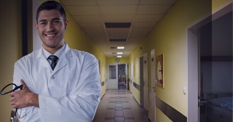 Smiling doctor with hospital hallway in the background, healthcare and medical professional concepts