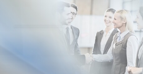 Obraz premium Composition of happy diverse business team shaking hands with motion blur