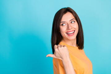 Close up photo of cheerful pretty cute lady wear trendy orange clothes arm direct empty space look...
