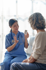 Young asian caretaker with 60s asia elderly woman consulting and encourage, take a history and recommend the right treatment, recommend taking painkillers and cure cancer