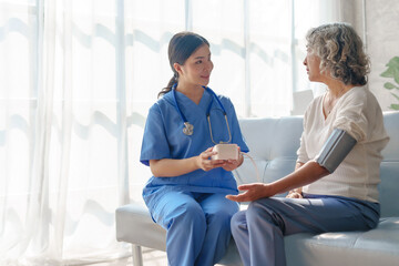 Obraz premium Young asian caretaker with 60s asia elderly woman consulting and encourage, take a history and recommend the right treatment to live happily in retirement, Measure blood pressure and heartbeat