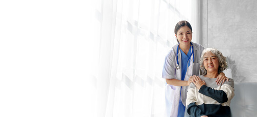 Fototapeta premium Young asian caretaker with 60s asia elderly woman consulting and encourage, take a history and recommend the right treatment, holding hands and encouraging