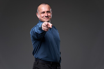 Smiling businessman pointing at camera