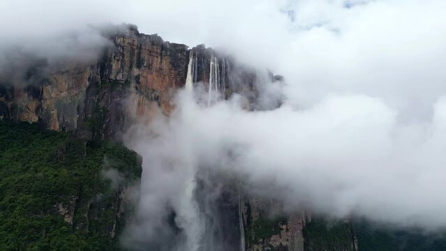 Aerial view through the clouds to the Angel Falls waterfall. A huge water stream falls from the high mountain. The tallest uninterrupted waterfall in the world. Canaima National Park, Venezuela