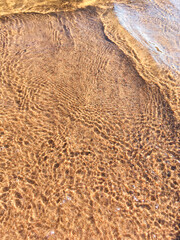 Sandy beach and close up of sea water. Summer natural background.