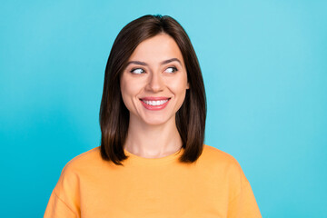 Portrait of optimistic satisfied cute woman with bob hairstyle dressed yellow t-shirt look empty space isolated on blue color background