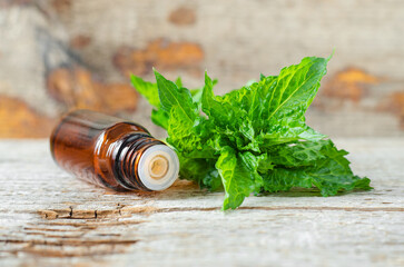 Small glass bottle with essential peppermint oil. Aromatherapy, sauna, homemade spa and herbal...