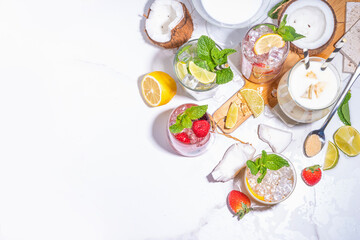 Summer cocktails drinks. Classic alcoholic long drink mocktail versions, various beverages, lemonades with berries, lime, orange, coconut, ice on white marble background 