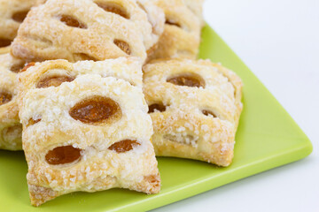 Close up of baked, bite size, apple strudel pastry on pastel green plate in healthy diet portions