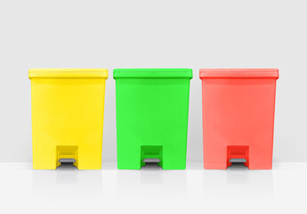 Yellow, green, red lidded bins on a white background.