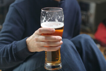 a person holds a mug with beer in his right hand