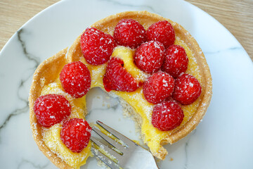delicious fruit tart. sweet pastry dessert topped with lemon cream and fresh raspberries. A sweet treat 