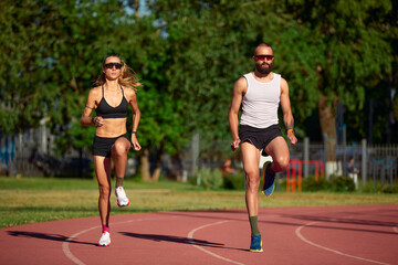 Obraz premium Diversity training man and woman at the stadium, athletics running