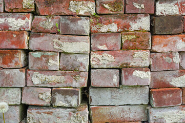 a stack of old used bricks with concrete. textured background 