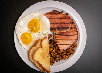 Two eggs, ham, potatoes and toast