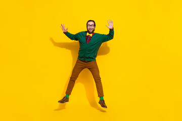 Fototapeta na wymiar Full body portrait of active overjoyed person jumping have good mood isolated on yellow color background