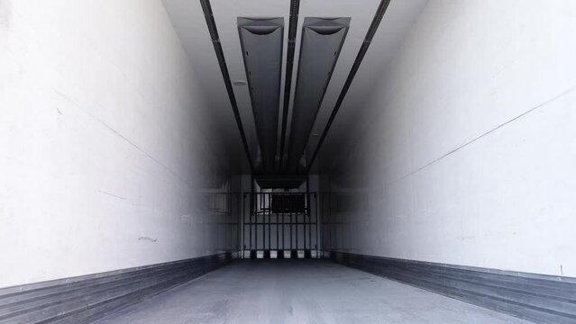 Motion inside empty light workbody of large contemporary truck transporting food products standing in market storehouse yard