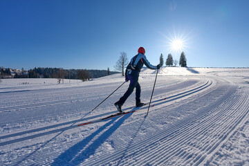 nice, active woman cross country skiing in the Bregenz Forest Mountains near Sulzberg, Vorarlberg, Austria    