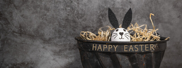 Happy Easter background banner holiday greeting card - Funny easter bunny in easter nest on concrete wall