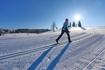 nice, active woman cross country skiing in the Bregenz Forest Mountains near Sulzberg, Vorarlberg, Austria    