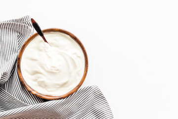 White sauce sour cream or yogurt in wooden bowl, top view