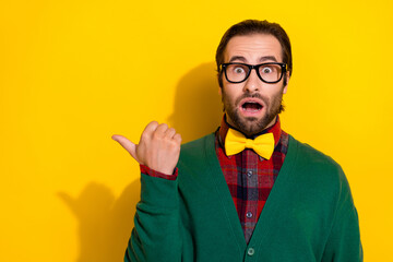 Photo portrait of young handsome man eyewear impressed point empty space dressed stylish green clothes isolated on yellow color background