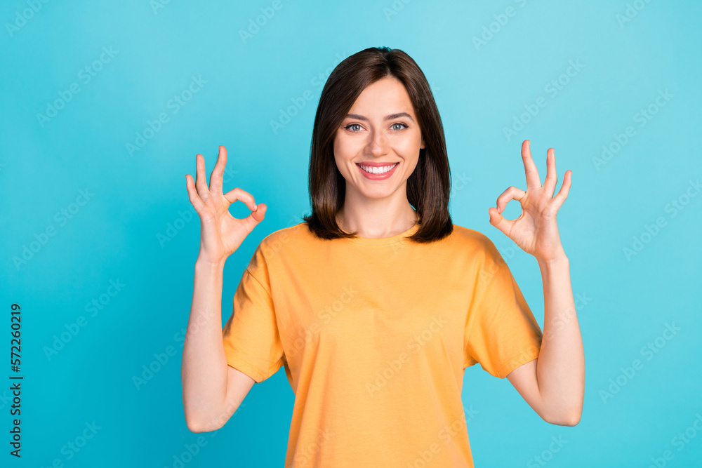 Sticker Portrait of charming cheerful girl beaming smile hands fingers demonstrate okey symbol isolated on blue color background