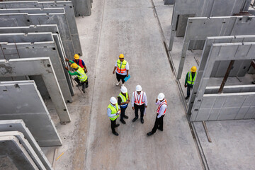 Aerial top view of architect and engineer discussing building plan at construction building site in...