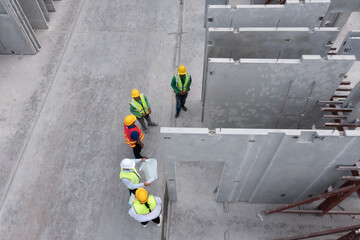 Aerial top view of architect and engineer discussing building plan at construction building site in...