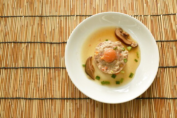 steamed chop pork topping salty egg yolk with mushroom in gravy sauce on plate