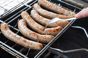 Grilling sausages on the steel grid