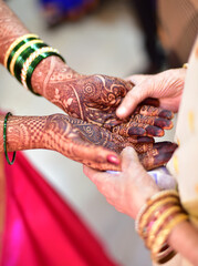 Close up view of hand of a bride and grandparents holding hands together performing rituals in...