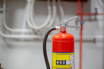 The red fire extinguisher is in the building for fire prevention and safety.