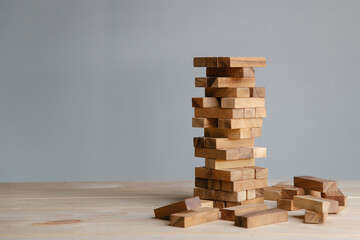 Planning,risk and strategy in business, businessman placing wooden block on a tower.