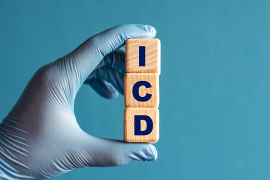 ICD is an acronym on cubes held by a hand in a blue glove