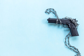 Hand gun weapon in chains - illegal use of weapons concept