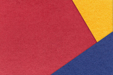 Fototapeta premium Texture of craft dark red paper background with yellow and blue border. Vintage abstract wine cardboard.